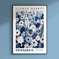 a blue and white flower market poster hanging on a wall
