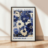 a blue and white flower market poster hanging on a wall