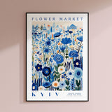 a blue and white flower market poster hanging on a wall