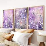 a bed topped with lots of pillows next to two paintings