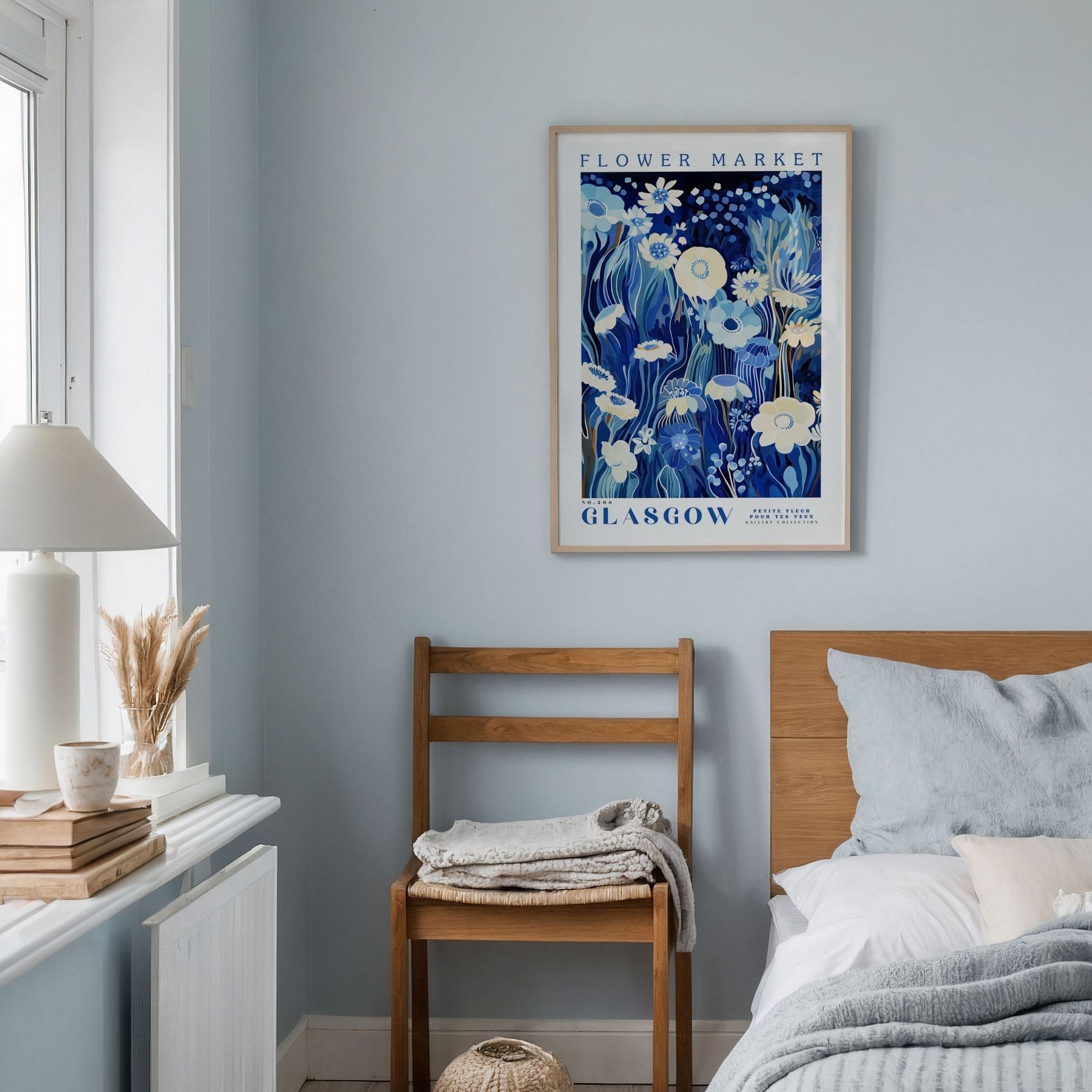 a bedroom with a bed, chair and a painting on the wall
